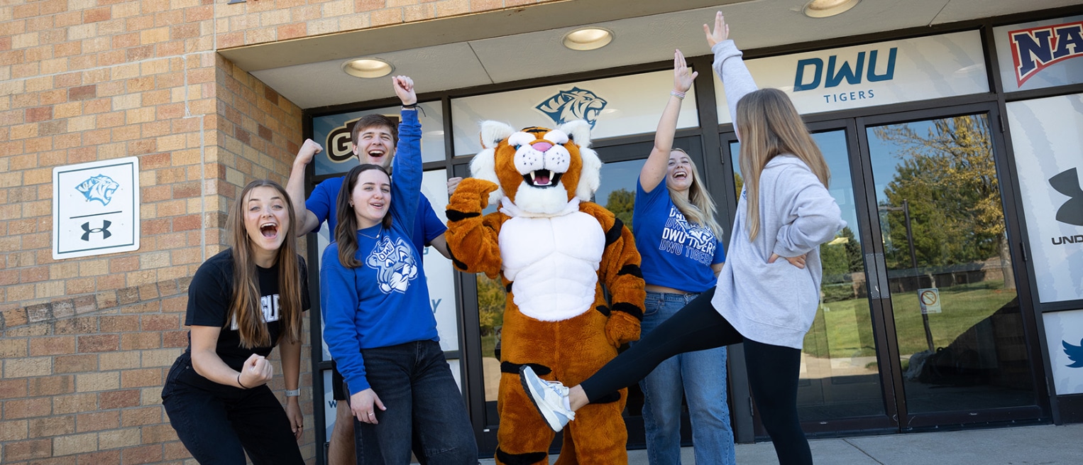 Wesley the Tiger cheering with DWU students